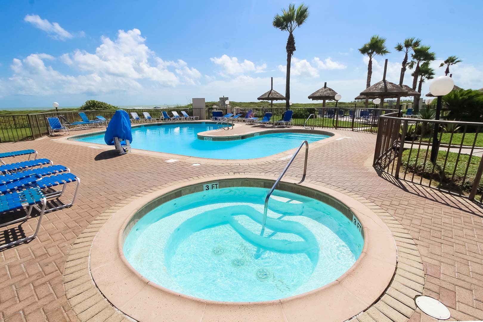 A peaceful outdoor swimming pool and Jacuzzi  at VRI's Royale Beach and Tennis Club.
